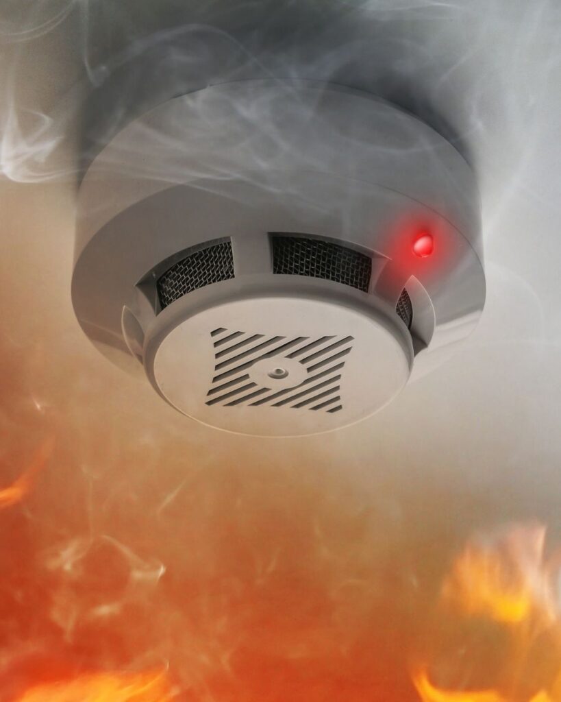 Technician installing smoke detector for fire alarm system